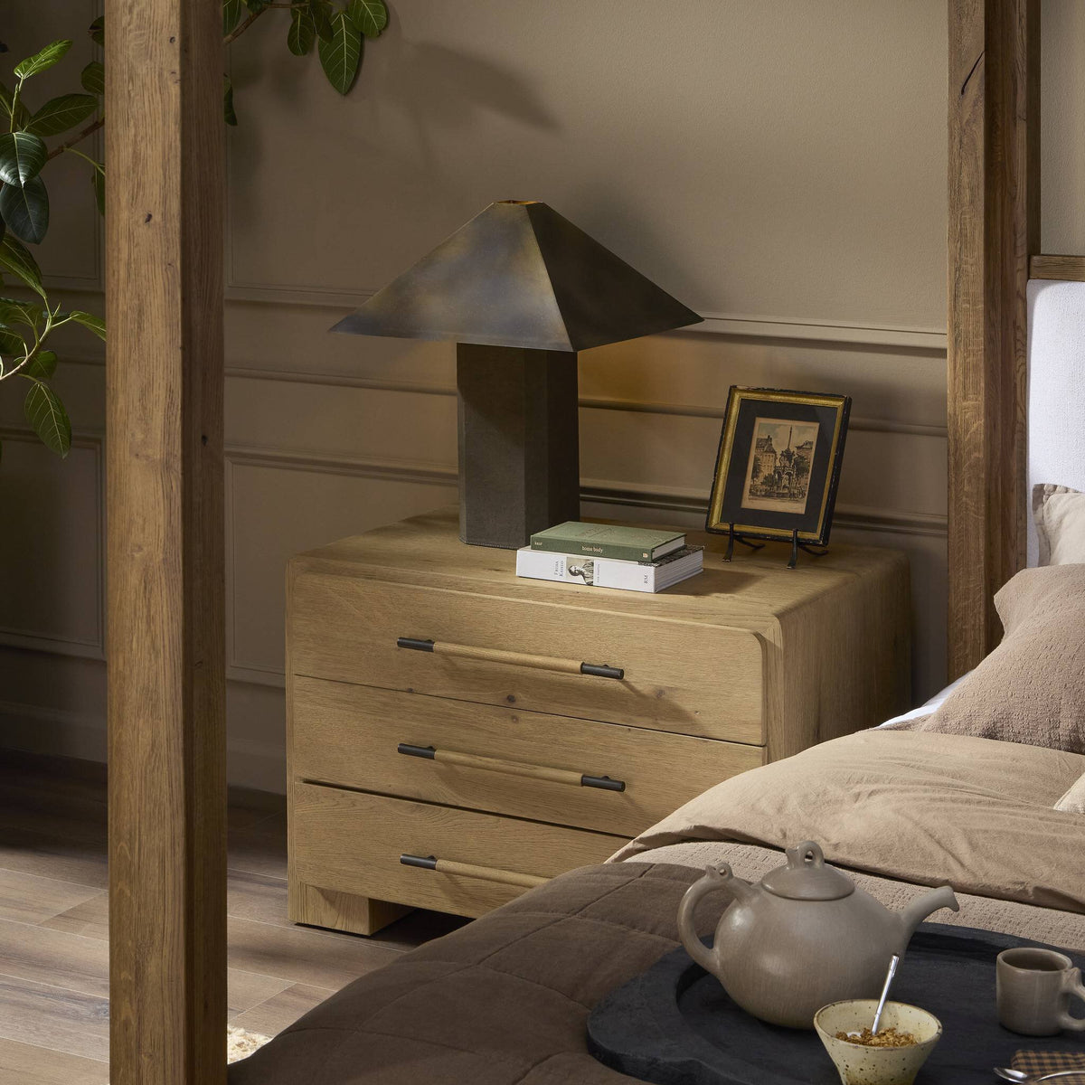 Forest green canvas table lamp with a unique geometric base in a cozy bedroom setting.