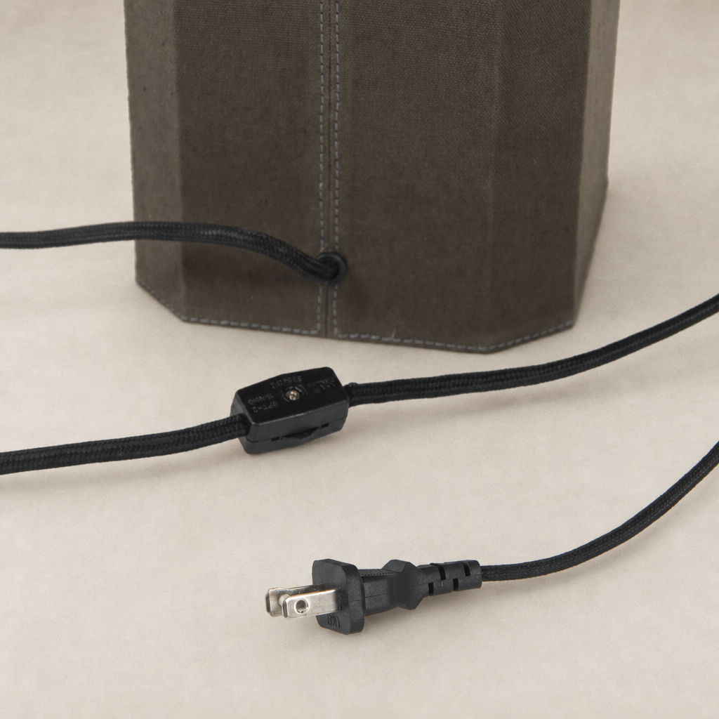 Forest green canvas table lamp with a black power cord and switch detail.