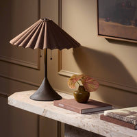 Espresso canvas table lamp with a pleated shade on a stylish marble surface.