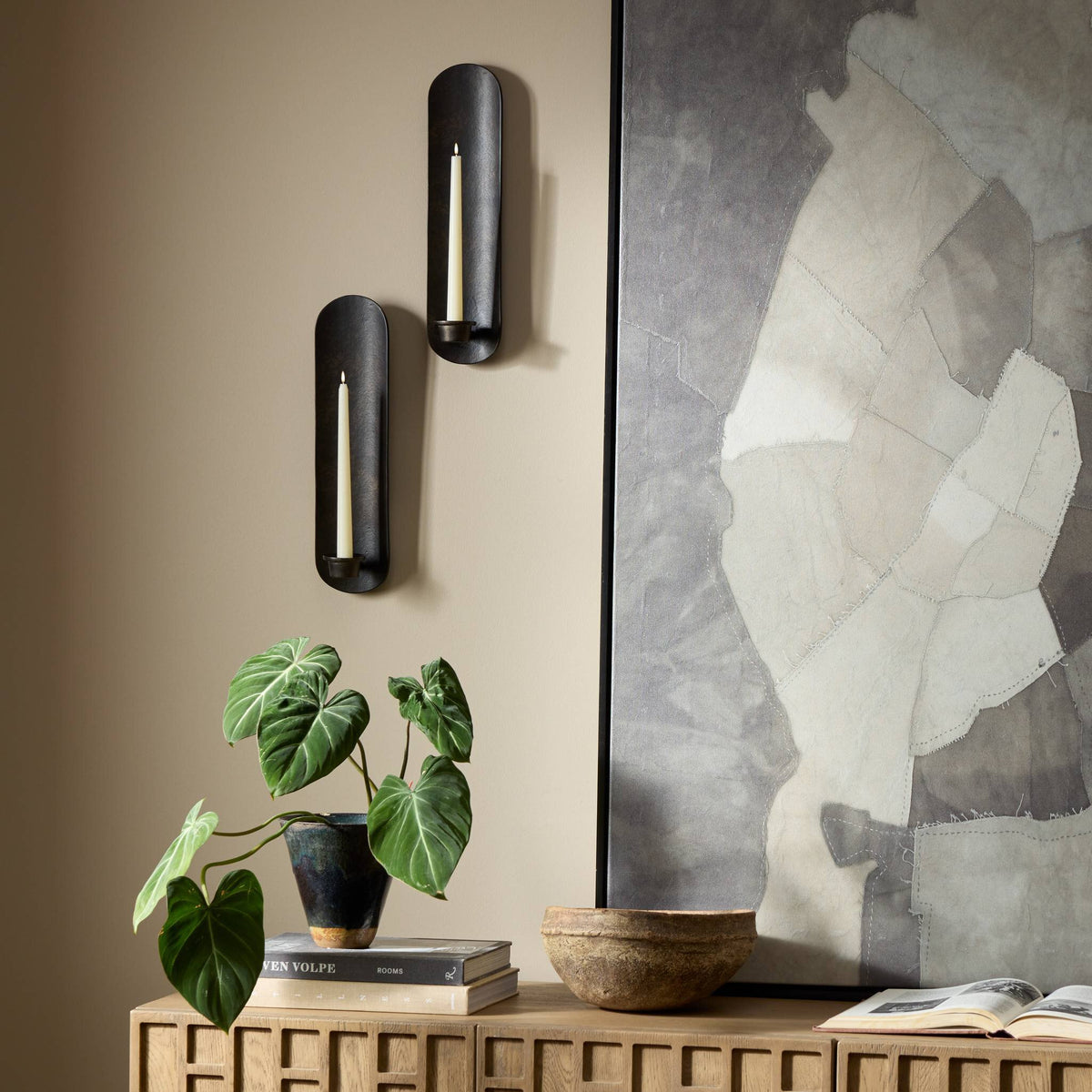 Zola Wall Mounted Candle Holder set in distressed bronze against a stylish wall.