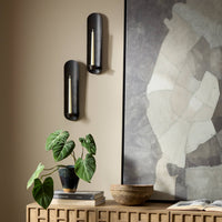 Zola Wall Mounted Candle Holder set in distressed bronze against a stylish wall.
