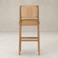 Kauri Bar + Counter Stool in Maestro Camel featuring woven backrest and wooden legs.