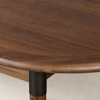 Cortina Oval Extension Dining Table in toasted walnut showcasing smooth, rich wood grain and rounded edges.