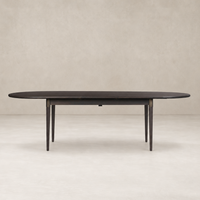 Cortina Oval Extension Dining Table in black mango with sleek, tapered legs and elegant design.