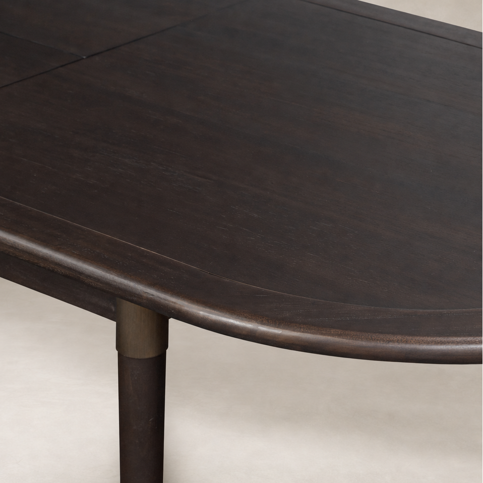 Cortina Oval Extension Dining Table in black mango with smooth, rounded edges.