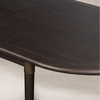 Cortina Oval Extension Dining Table in black mango with smooth, rounded edges.