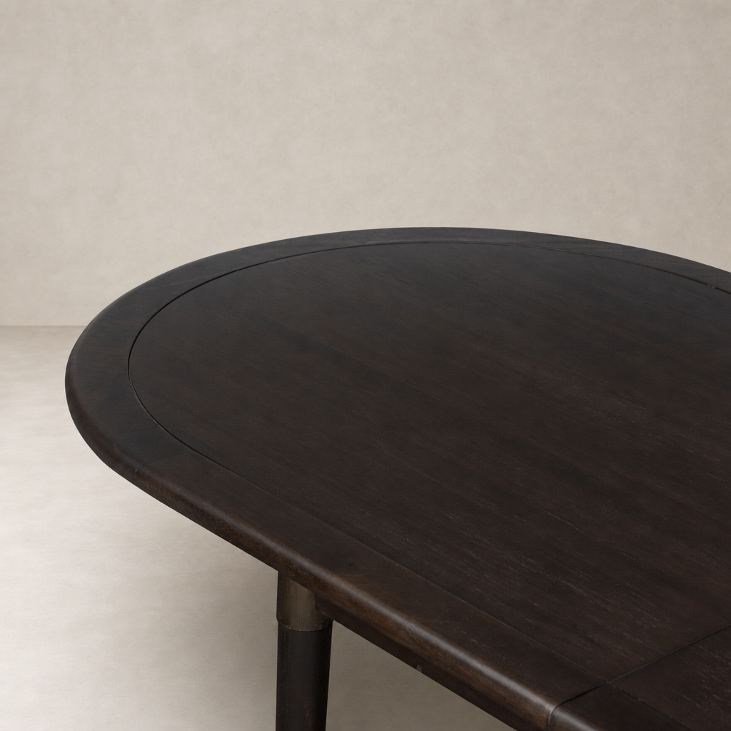 Cortina Oval Extension Dining Table in black mango wood with smooth, rounded edges.