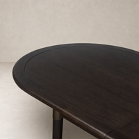 Cortina Oval Extension Dining Table in black mango wood with smooth, rounded edges.
