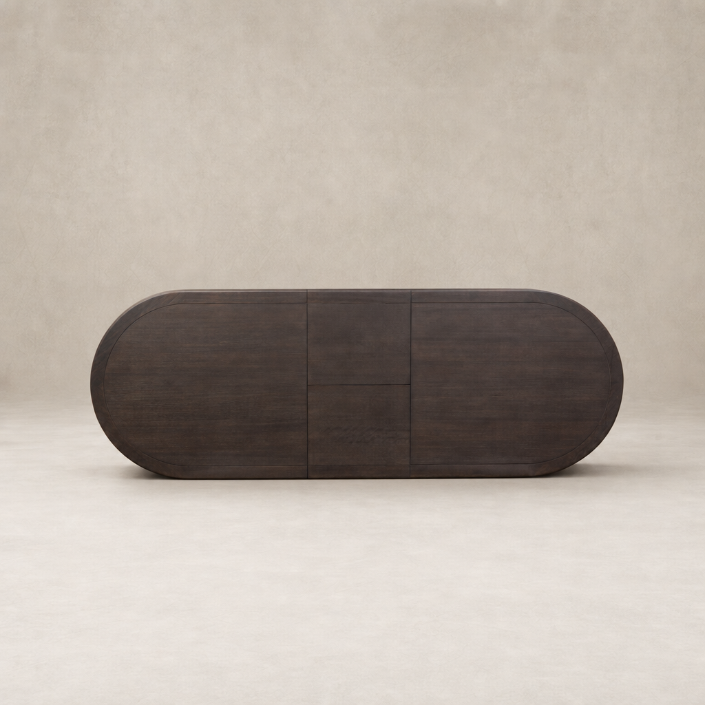 Cortina Oval Extension Dining Table in black mango with smooth, rounded edges and minimalist design.