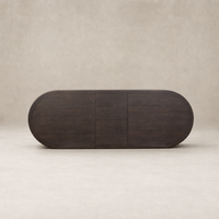 Cortina Oval Extension Dining Table in black mango with smooth, rounded edges and minimalist design.