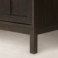 Close-up of Bristol Cabinet in Smoked Black, highlighting its sturdy legs and rich wood finish.