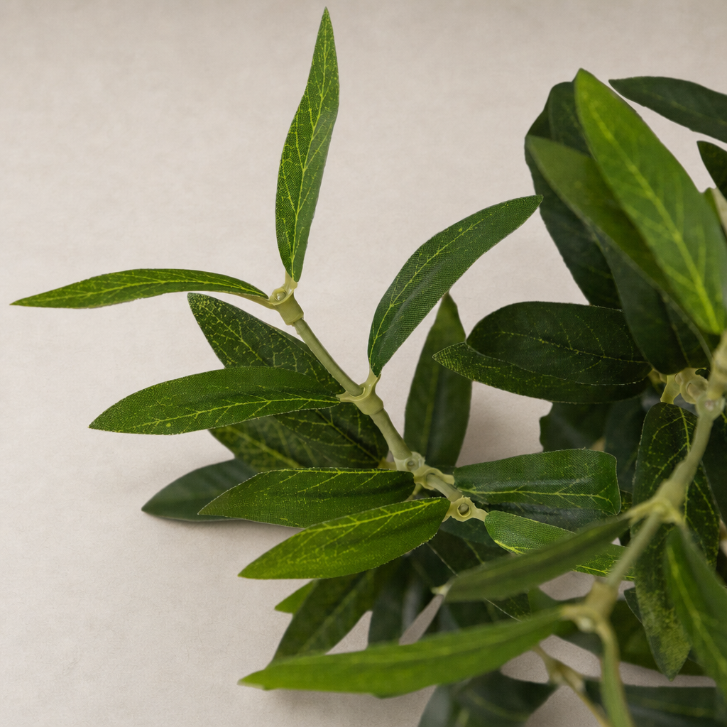 Close-up of vibrant leaves from the Iris Olive Tree Wide in faux material.