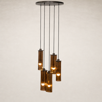 Chandelier with cylindrical glass shades and warm light bulbs.