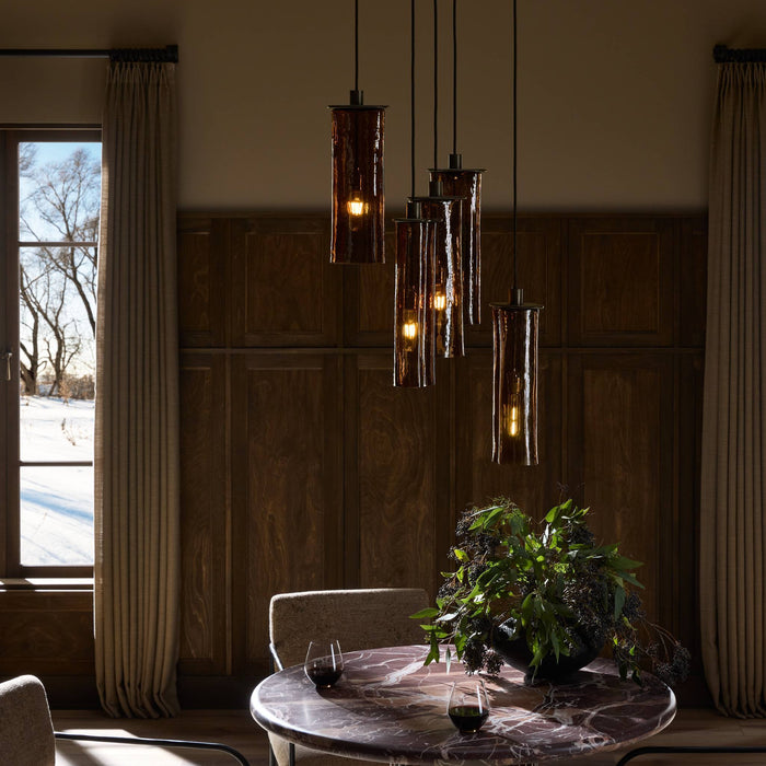 Chandelier with elongated glass shades above a dining table.