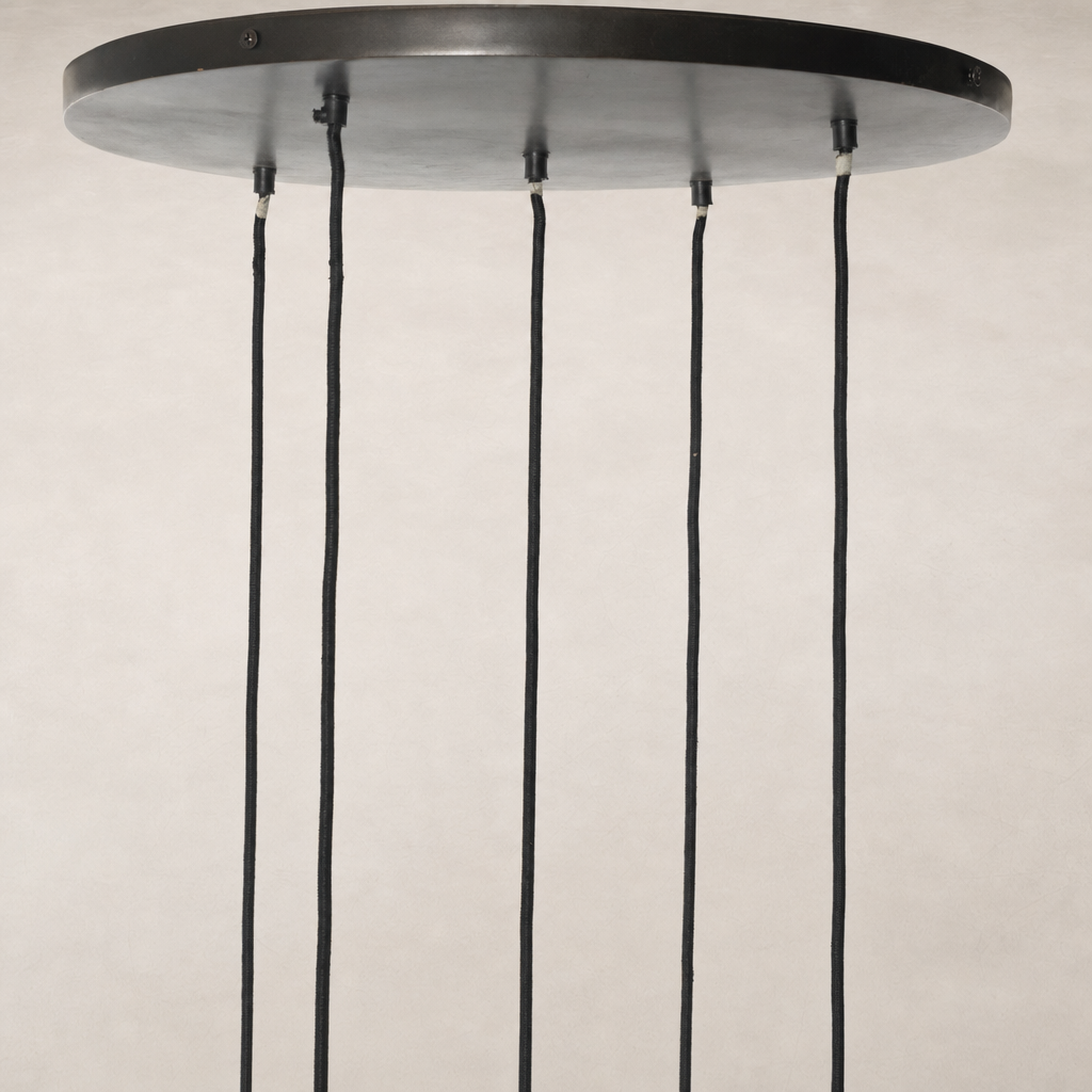 Chandelier with a sleek round ceiling plate and hanging cords.
