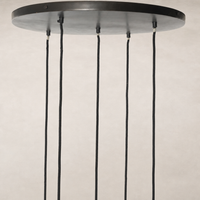 Chandelier with a sleek round ceiling plate and hanging cords.