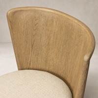 Skye Dining Chair in Irving Flax with a curved wooden back and soft textured seat.