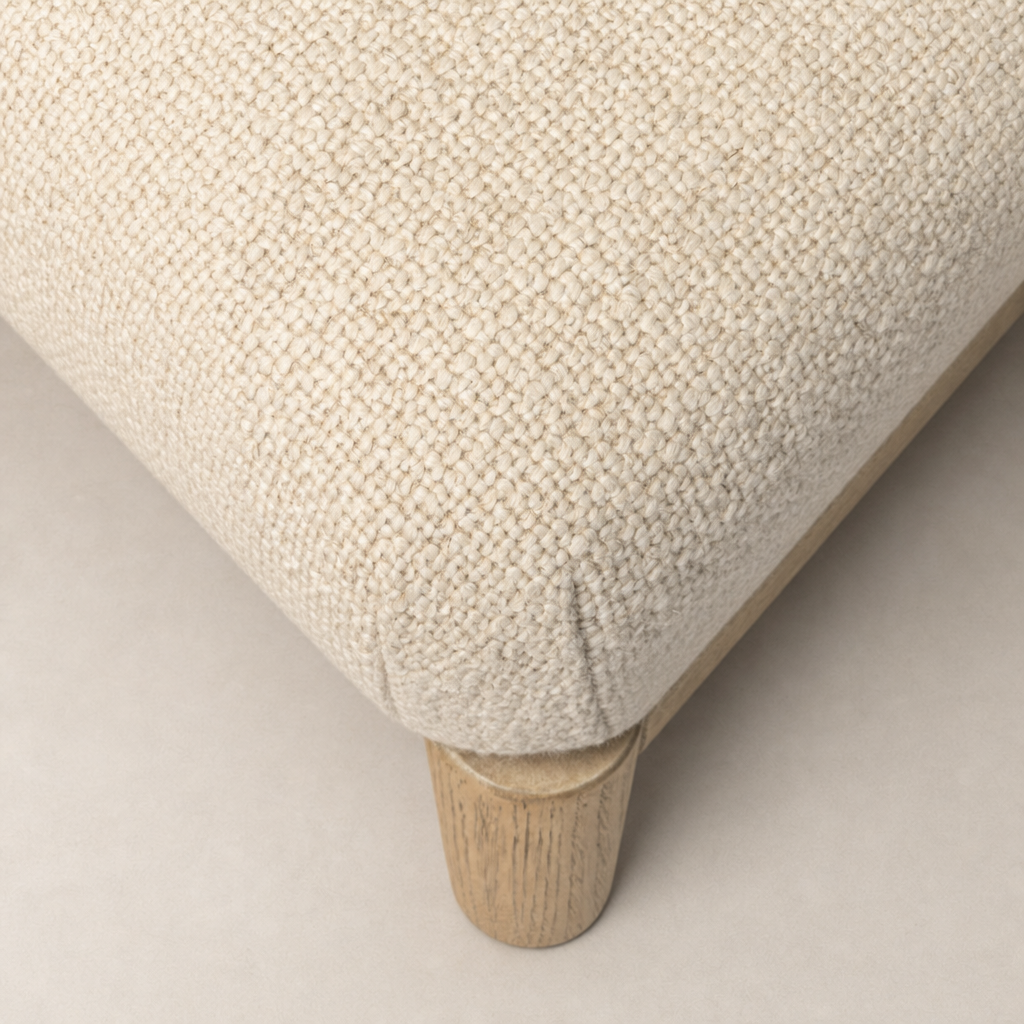 Close-up of the Skye Dining Chair in Irving Flax, highlighting its textured fabric and wooden legs.