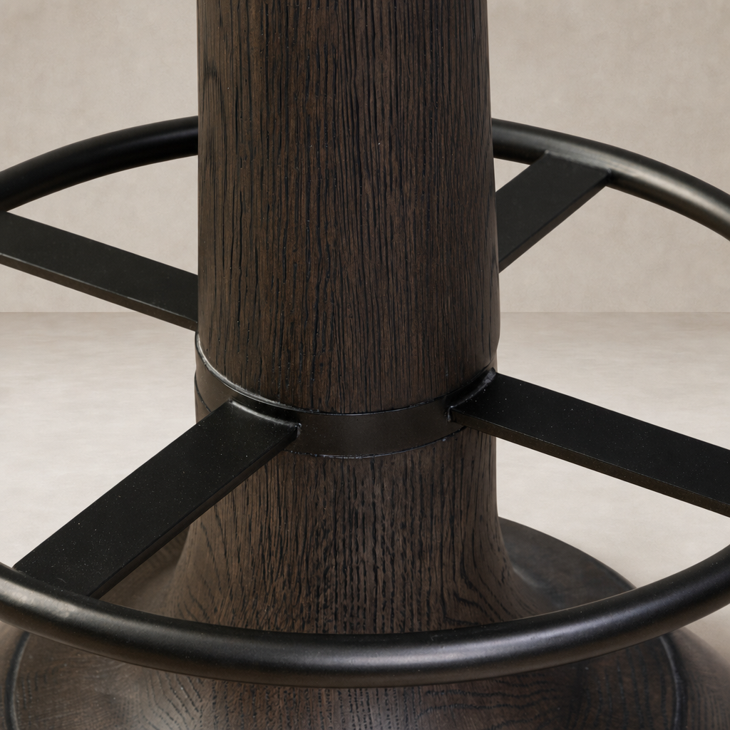 Close-up of a counter stool's sturdy wooden base with black metal supports.