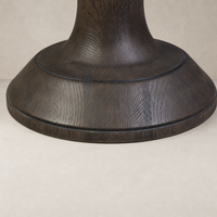 Close-up of the sturdy wooden base of a counter stool in dark finish.