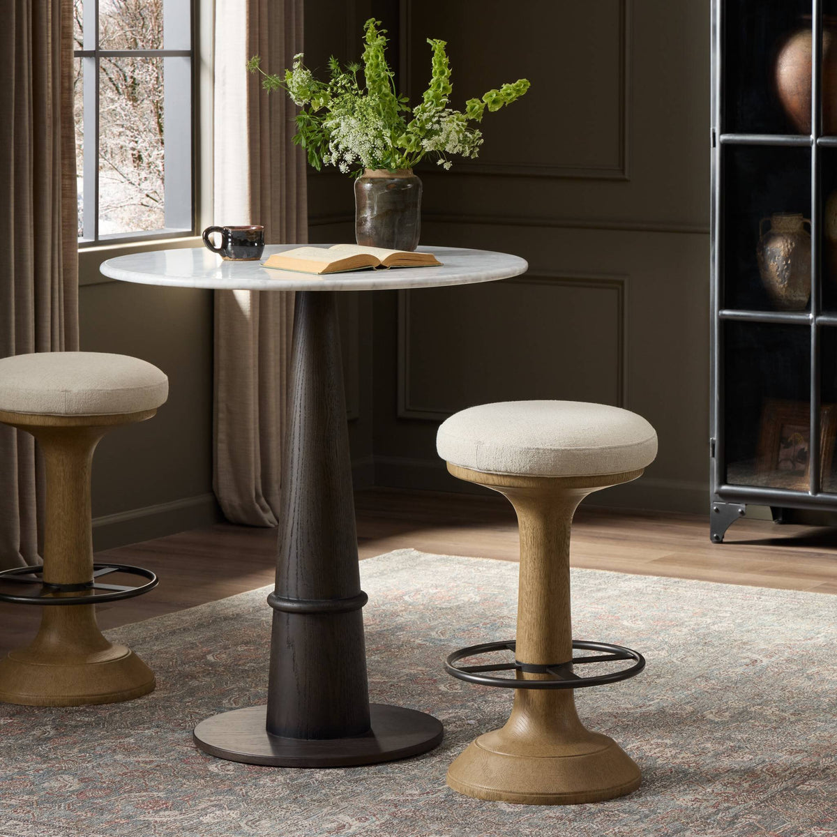 Antwerp Natural counter stool with a plush seat and curved wooden base.