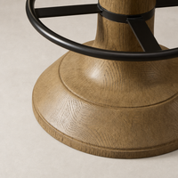 Natural wood counter stool base with smooth finish and metal footrest detail.