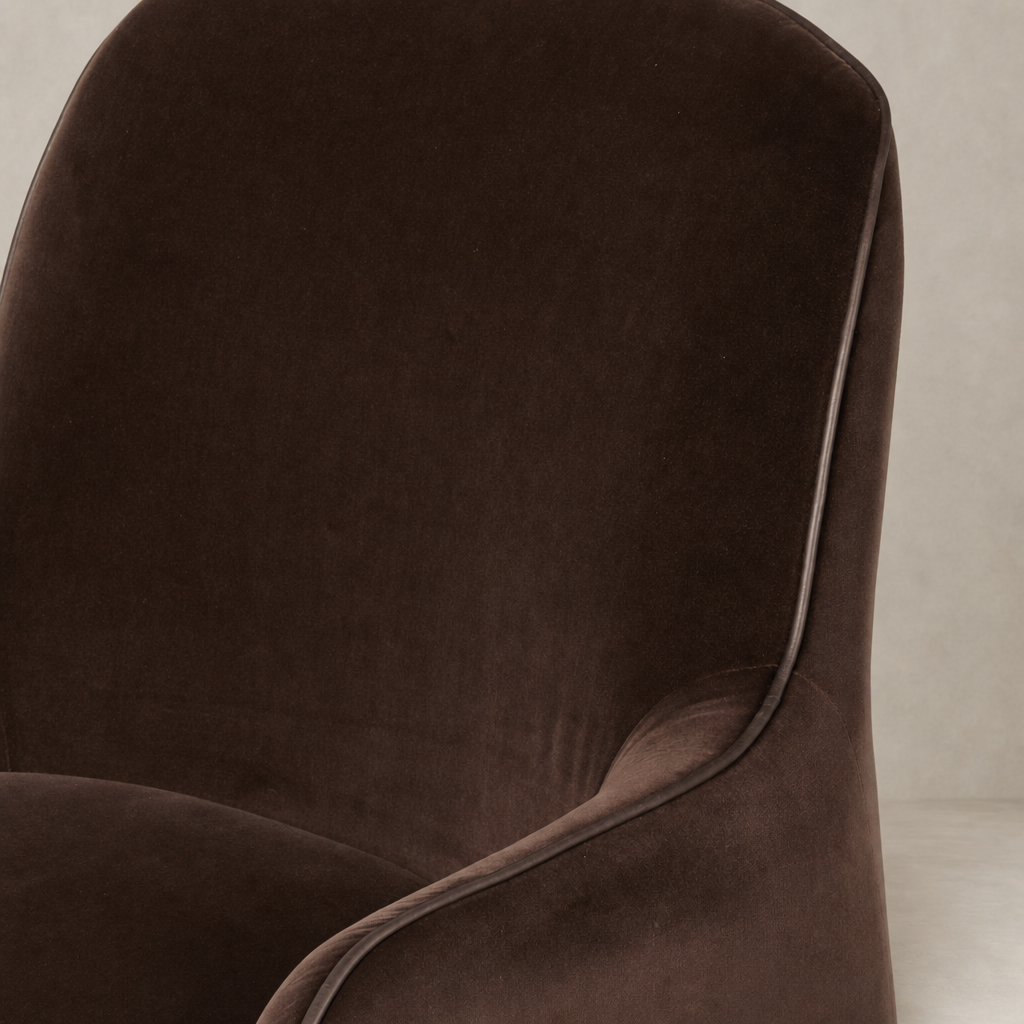 Paloma Swivel Chair in Surrey Cocoa with a sleek, soft velvet finish and curved design.