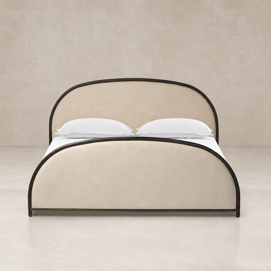 Curved bed in Savoy Parchment fabric with black metal accents.