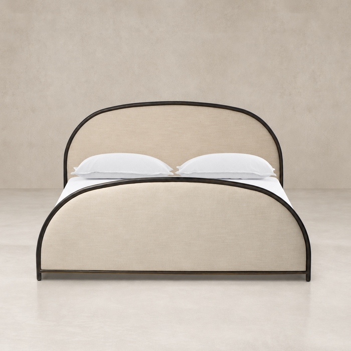 Curved bed in Savoy Parchment fabric with black metal accents.