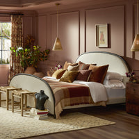 Savoy Parchment bed with upholstered headboard, styled with decorative pillows in a cozy bedroom.