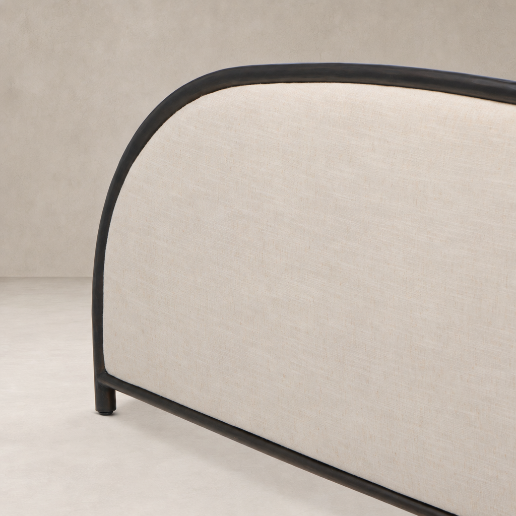 Modern bed with Savoy Parchment fabric and sleek black metal frame.