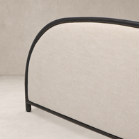 Modern bed with Savoy Parchment fabric and sleek black metal frame.