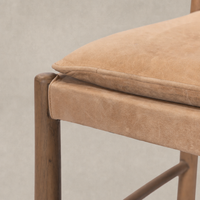 Close-up of a Winchester Beige dining chair with padded seat and wooden frame.