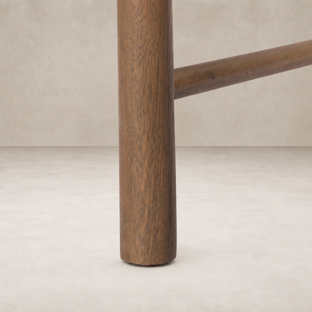 Close-up of the sturdy wooden leg of a Winchester Beige dining chair.