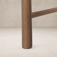 Close-up of the sturdy wooden leg of a Winchester Beige dining chair.