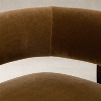 Bodhi Swivel Chair in Surrey Ochre showcasing soft, velvety upholstery and smooth curves.