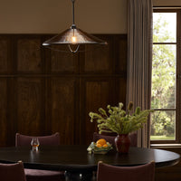 Amber glass pendant lamp with a sleek, conical shape illuminating a dining area.