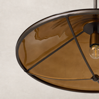 Amber glass pendant light with a modern metal frame and elegant design.