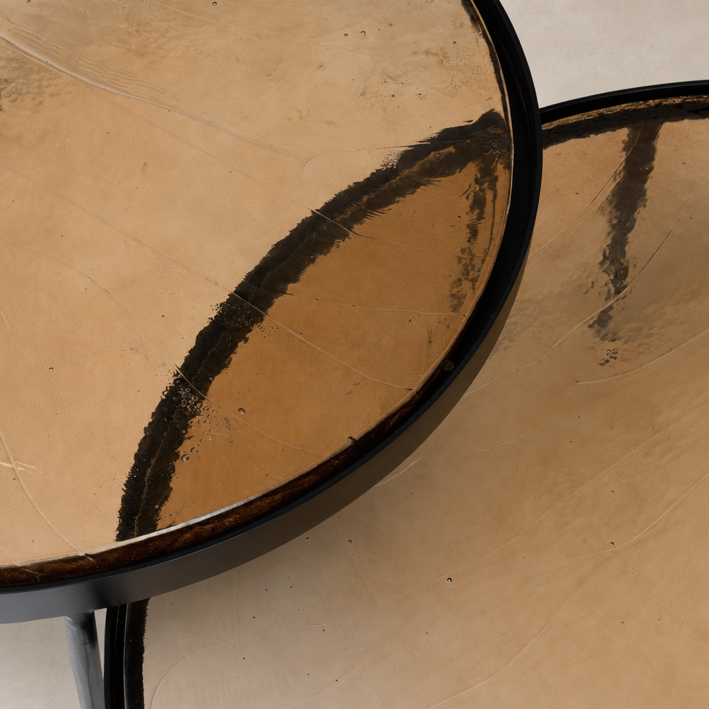 Smoked brown cast glass surfaces of Kiko nesting tables showcasing elegant curves.