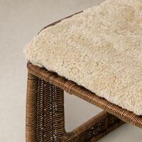 Beige Shorn Shearling Ingrid Dining Chair with textured seat and woven frame.