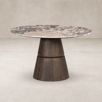 Round dining table featuring Calacatta Viola marble top and a unique wooden base.