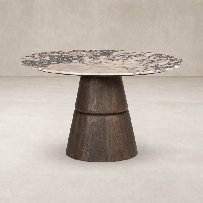 Round dining table featuring Calacatta Viola marble top and a unique wooden base.