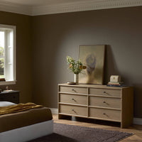 Sandy oak 6 drawer dresser in a cozy bedroom setting with floral decor.