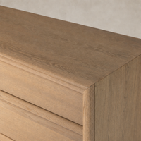 Sandy oak six-drawer dresser featuring a smooth, minimalist surface and clean lines.