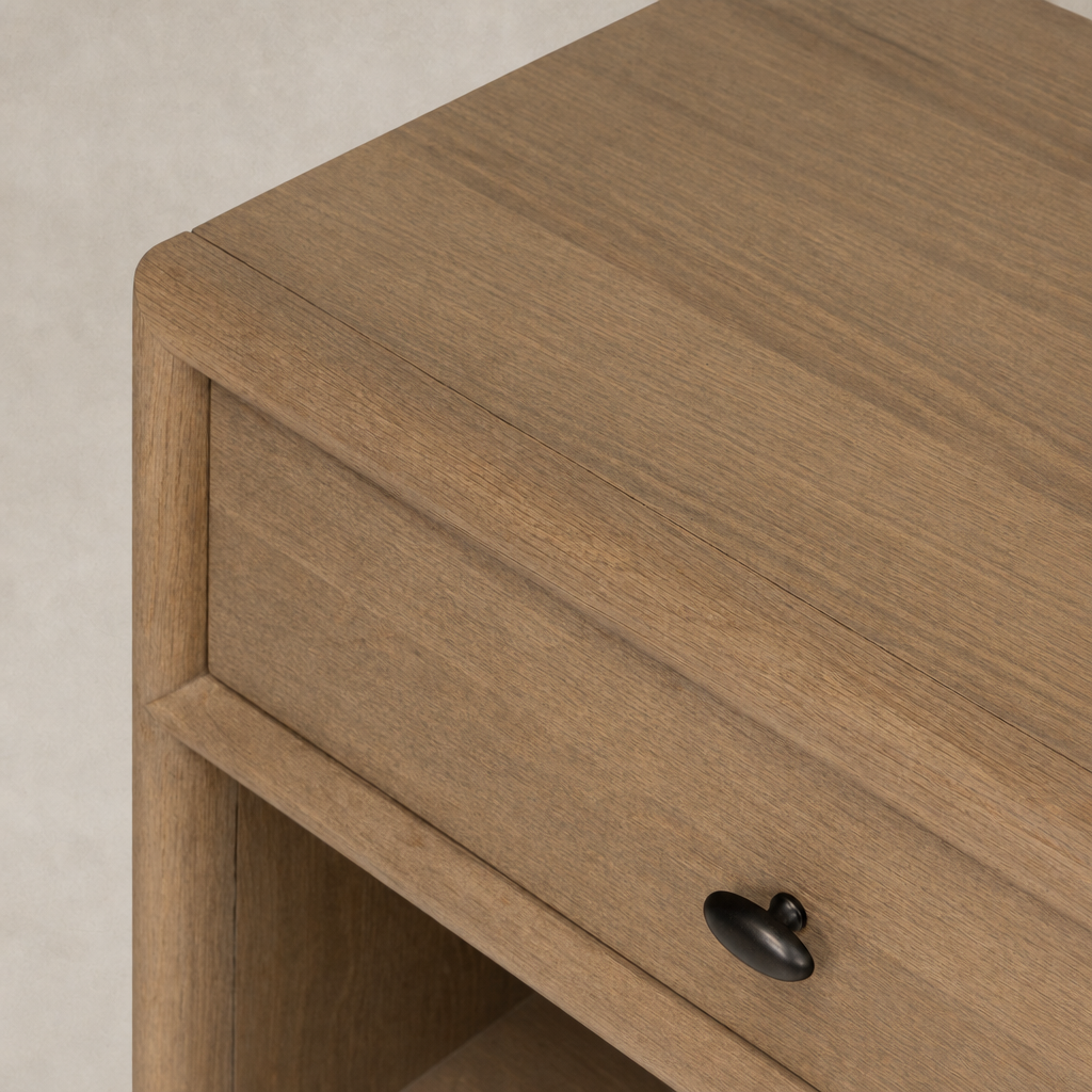 Sandy oak nightstand with a smooth finish and a black pull knob.