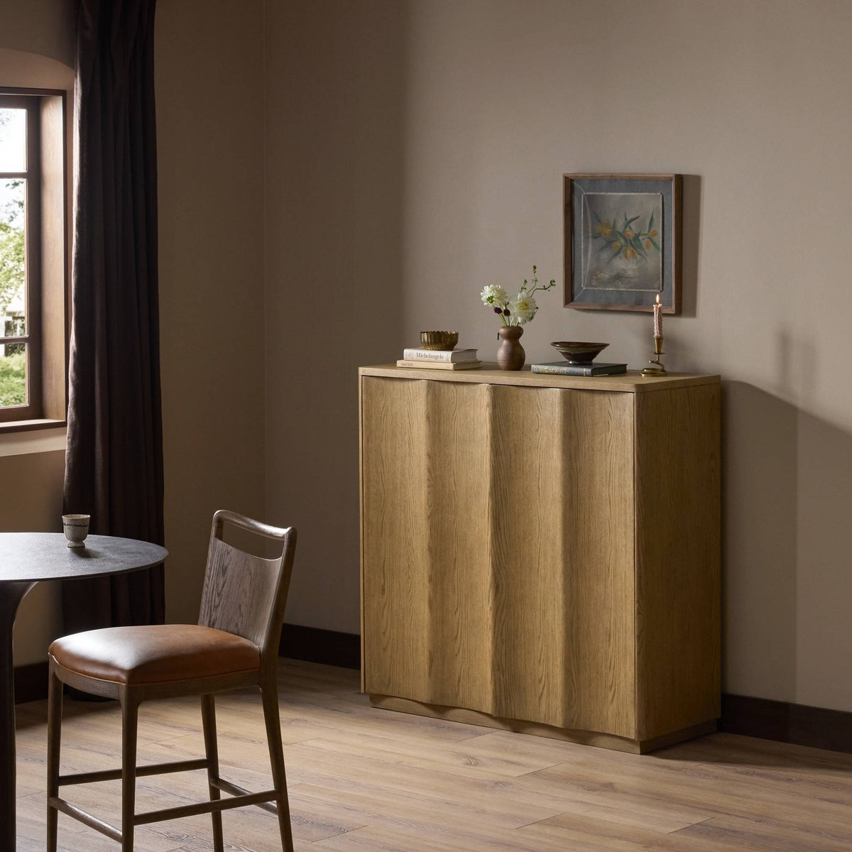 Felix Small Cabinet in drifted oak with textured paneling, set in a cozy room.