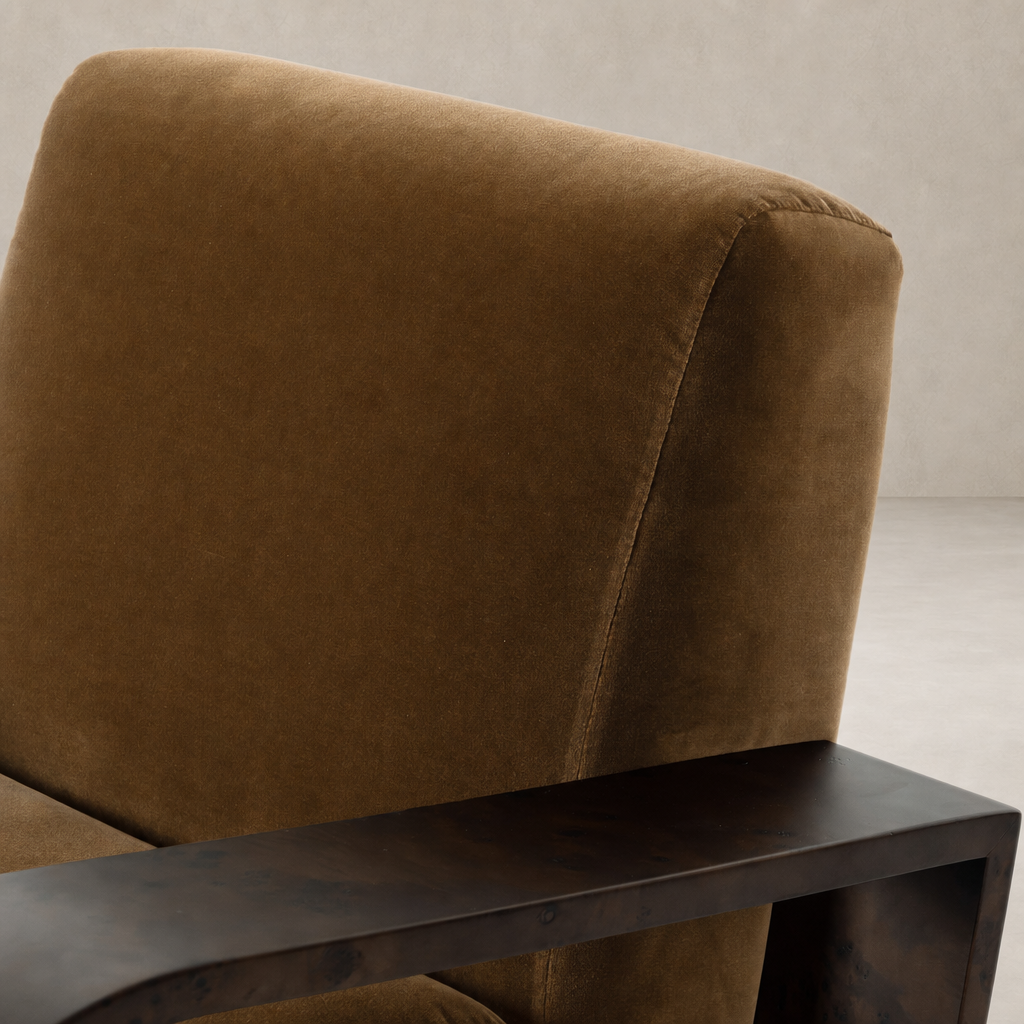 Orchid Chair in Surrey Ochre featuring plush upholstery and a sleek metal armrest.
