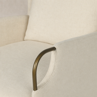 Close-up of Ada Chair in Bergamo Parchment highlighting soft fabric and sleek brass armrest.