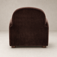 Chiara Chair in Monte Chocolate featuring a soft, curved back and wooden legs.
