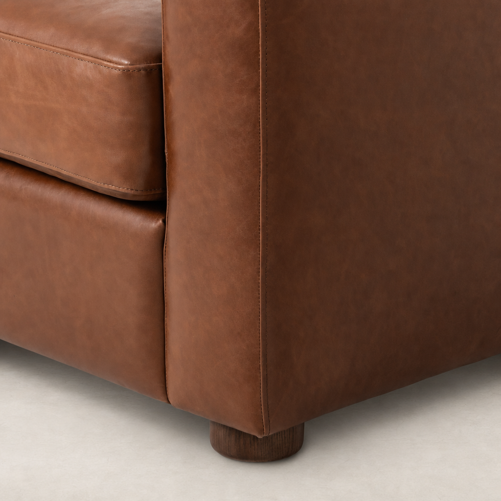 Close-up of the Chiara Chair in Dulane Mahogany showcasing its rich leather texture and wooden base.
